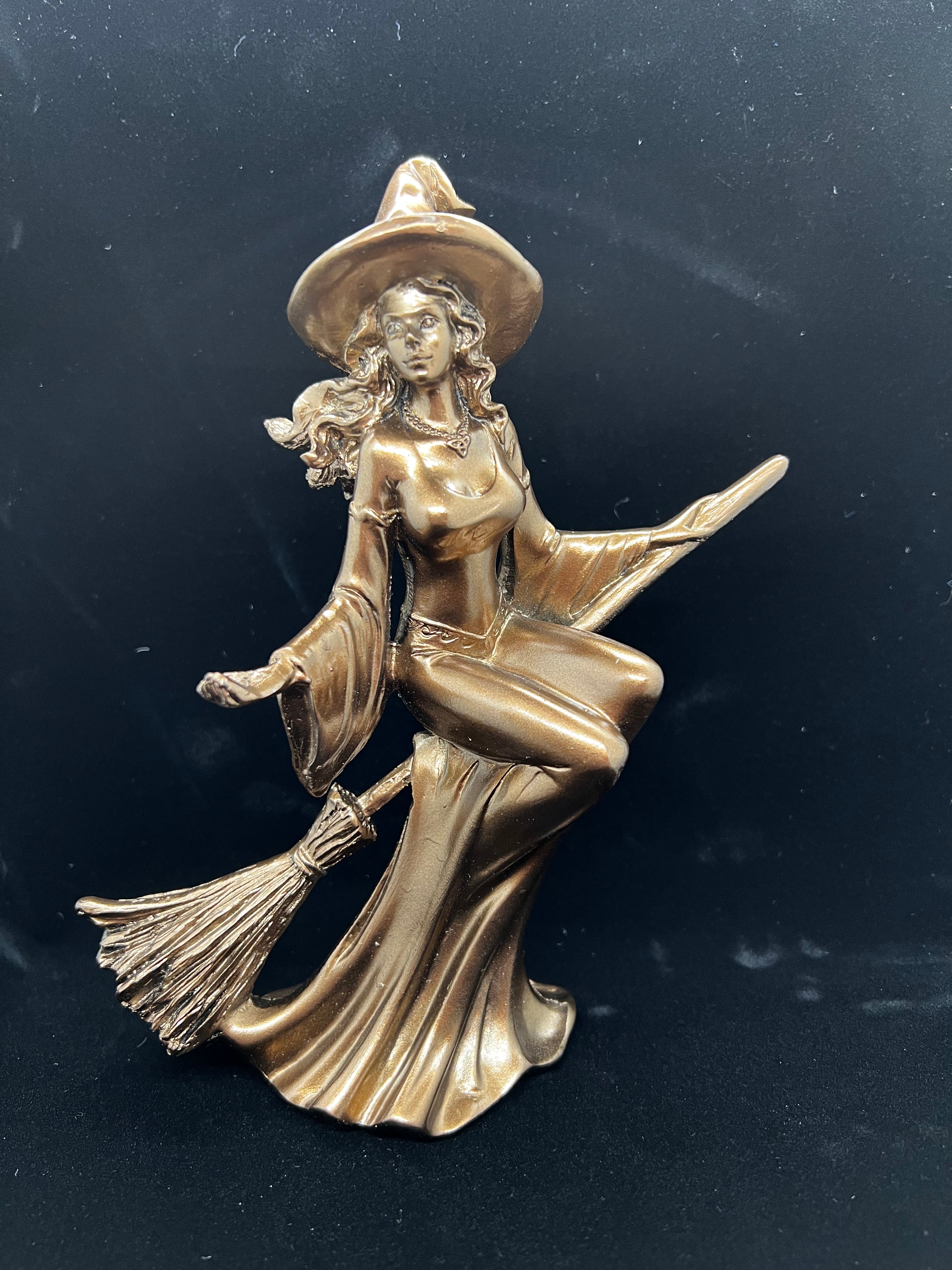 Witch on a broom statue